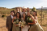 Bride surrounded by her bridesmaids holding bouquets in a group portrait
