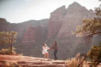 Couple dancing playfully together on Sedona's red rocks during their elopement