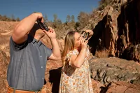 Couple taking a Polaroid photo of each other on the rocks at Water Wheel Falls in Payson