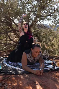 Bride relaxing on a picnic blanket with champagne during her Sedona elopement
