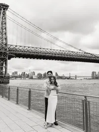 A timeless black and white portrait of a couple embracing by the water, capturing a genuine connection during a multi-day wedding celebration.