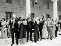 Guests rise and applaud during the ceremony in the Boston Public Library courtyard, columns and arched windows behind them.