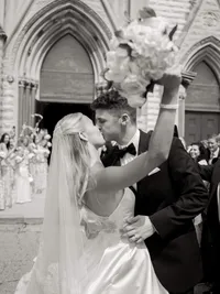 Classic black and white wedding exit photo of a bride and groom kissing outside a cathedral after their Dayton Arcade wedding.