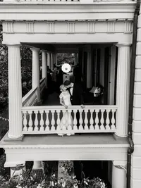 Timeless black and white editorial portrait of a couple kissing on the historic balcony of the Edmondston-Alston House in Charleston, SC.
