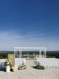 A wide, high-angle view of an outdoor wedding ceremony at The View at Bluemont, showcasing refined composition and the intentional imagery of the vast mountain horizon.