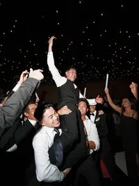 Groomsmen lifting groom at Hall of Lights Dallas Texas — dramatic ceiling installation photography