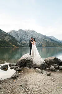 Elopement couple stands on rock at Jenny lake in Grand Teton National Park
