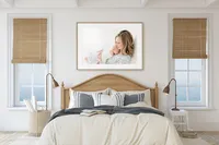 Large framed portrait of a mother and baby displayed above a bed as heirloom wall art