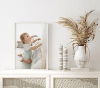 Framed baby portrait displayed as wall art above a styled dresser in a Niceville, Florida home