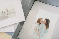 Custom matted prints featuring beach family portraits displayed in a linen keepsake box