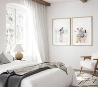 Two framed Destin beach family portraits styled as wall art in a bright coastal bedroom