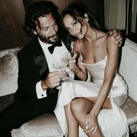superherodesignco_34572_Newlyweds_sitting_together_on_a_velve_a9711ee0-3bd9-474c-90ca-340b4c9bd35c_0