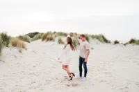 Een stel deelt een vrolijk moment tijdens een loveshoot in de natuur, vastgelegd door Monica Stout Fotografie in een ontspannen setting.