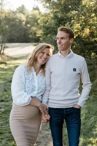 Een stel geniet van een ontspannen zwangerschapsfotoshoot in de natuur, hand in hand, vastgelegd door Monica Stout Fotografie in Sliedrecht.