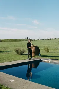 Man playing a saxaphone by a pool for a Europe wedding cocktail hour