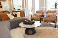 gray curved sofa with leather chairs