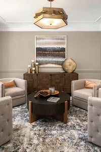 Living room design with conversational seating arrangement and bold light fixture. Residential interior design services in Waxhaw, North Carolina. Gracious Home Interiors.