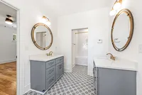 guest bathroom with custom tile and grey cabinets