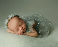 Newborn baby sleeping on a pale green blanket in a sparkly tulle outfit. Photographed by Inland Empire newborn photographer Kaitlyn Dawn Photography.