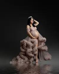Elegant studio maternity portrait of pregnant woman wearing a blush couture maternity gown and crown while standing in reflective water highlighting her baby bump photographed by best Yucaipa maternity photographer Kaitlyn Dawn Photography.