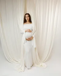 Full-length portrait of a pregnant woman in a white gown framed by soft fabric, highlighting her pregnancy during a Yucaipa maternity session with Kaitlyn Dawn Photography.