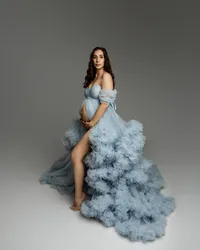 Pregnant woman in a dramatic blue tulle maternity dress posing gracefully in studio, photographed by Kaitlyn Dawn Photography in Yucaipa.