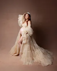 Fine art maternity portrait of a pregnant woman in a champagne tulle gown and crown posing gracefully in a studio photographed by Inland Empire maternity photographer Kaitlyn Dawn Photography.