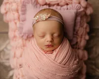 Newborn baby wrapped in light pink on a textured blush blanket. Photographed by Inland Empire newborn photographer Kaitlyn Dawn Photography.