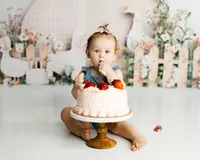 Baby exploring a strawberry birthday cake during a playful cake smash session. Photographed by Yucaipa baby photographer Kaitlyn Dawn Photography.