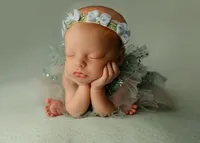 Sleeping newborn baby girl wrapped in a blush pink swaddle and posed on a textured blanket during a studio newborn photography session with newborn photographer Kaitlyn Dawn Photography.