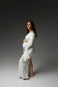 Expecting mom in a fitted white maternity gown posing in profile, highlighting her pregnancy during a Yucaipa session with Kaitlyn Dawn Photography.