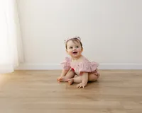 Flutter sleeves, a heart on her romper, and all the first birthday magic. Captured by Yucaipa cake smash photographer Kaitlyn Dawn Photography.