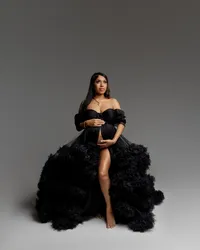 Pregnant woman seated in a black tulle maternity gown during a studio maternity portrait session by Kaitlyn Dawn Photograph