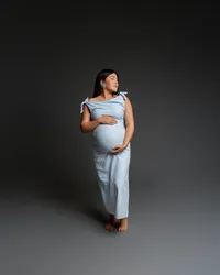Pregnant woman in a soft blue dress posing gracefully, highlighting her baby bump during a maternity session with Kaitlyn Dawn Photography in Yucaipa.