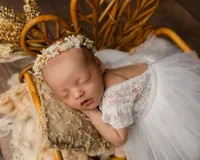 Newborn baby swaddled in pink with a delicate floral headband. Photographed by Inland Empire newborn photographer Kaitlyn Dawn Photography.