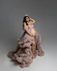 Pregnant woman wearing a blush ruffle maternity gown and crown during an elegant studio maternity photography session by Kaitlyn Dawn Photography.
