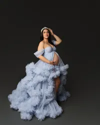 Expecting mother wearing a light blue ruffle maternity gown and crown during a dramatic studio maternity photography session by Kaitlyn Dawn Photography.