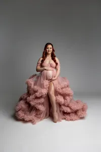 Studio maternity portrait of an expecting mother wearing a blush pink ruffle maternity gown photographed by Kaitlyn Dawn Photography.