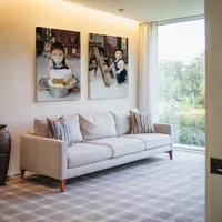 Bright living room featuring framed cake smash portraits of a one-year-old baby, Kaitlyn Dawn Photography, Yucaipa milestone and family photographer.