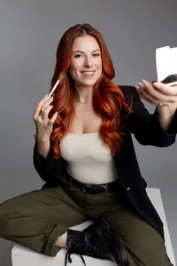 Woman with red hair holding mascara and compact mirror while seated at a table. Photograph by Yucaipa branding photographer Kaitlyn Dawn Photography.