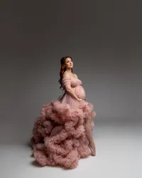 Side profile maternity portrait of an expecting mother in a blush pink ruffle gown captured during a studio maternity session by Kaitlyn Dawn Photography.