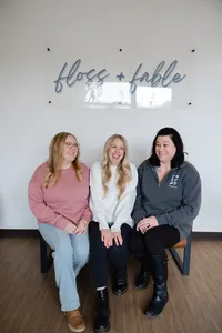Three women standing together and smiling in a bright studio branding portrait. Photograph by Yucaipa branding photographer Kaitlyn Dawn Photography.