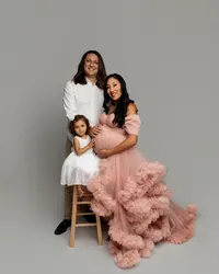 Studio maternity family portrait of expecting mother in a pink gown with partner and young daughter photographed by Kaitlyn Dawn Photography.