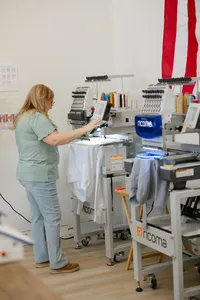 Embroidery machine in progress stitching on fabric in a bright workspace. Photograph by Yucaipa branding photographer Kaitlyn Dawn Photography.
