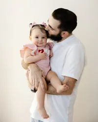 Celebrating his little girl with a kiss and a proud smile. Captured by Yucaipa cake smash photographer Kaitlyn Dawn Photography.