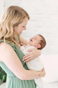 mom holding her newborn baby for their newborn photography session