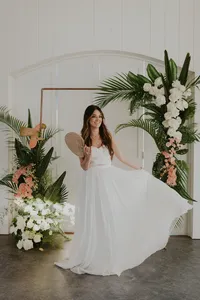 Bride shows off her stunning Vera Wang wedding dress in front of tropical summer floral archway