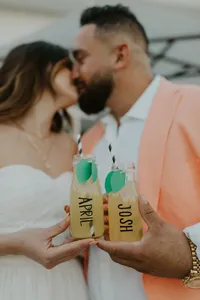 Bride and groom share a kiss and a lemonade together on their wedding day