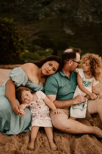 mom-resting-on-dads-shoulder-with-daughters-oahu