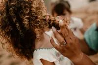 mom-touching-daughters-curly-hair-oahu-family-session